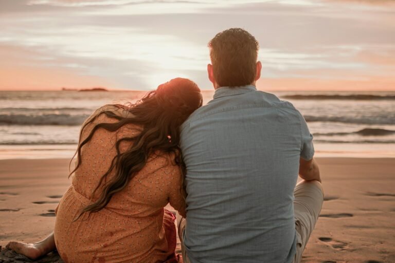 A couple watching the sunset on a beach