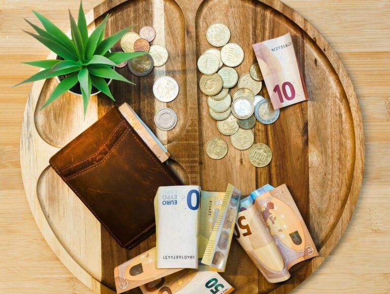 Foreign currency notes and coins beside a wallet
